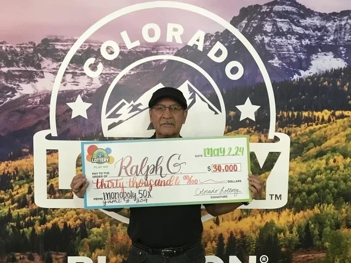 Ralph G. 手持 $30,000的超大支票，背景为科罗拉多州彩票
